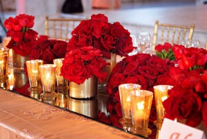 Red roses with gold vases along with small candles are the perfect decorations for an Oscar Party.